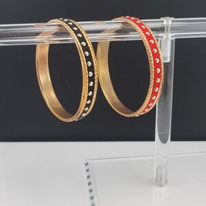 Set of gold tone red and black bracelets. GUC